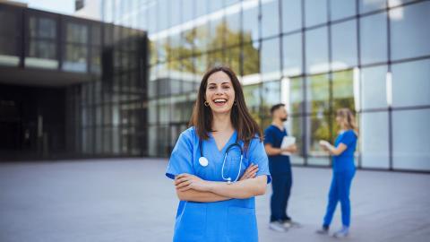 a female nurse smiling just outside the hospital building