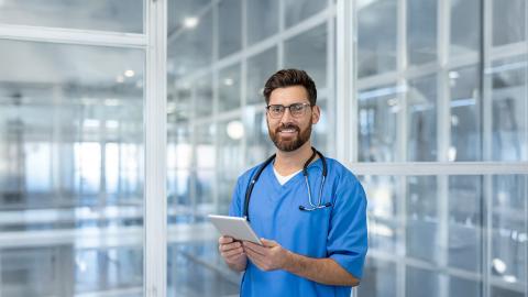 a male doctor checking the list of patients to attend