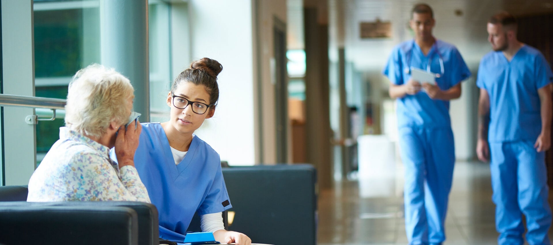 Nurse works with elderly patient during clinical.